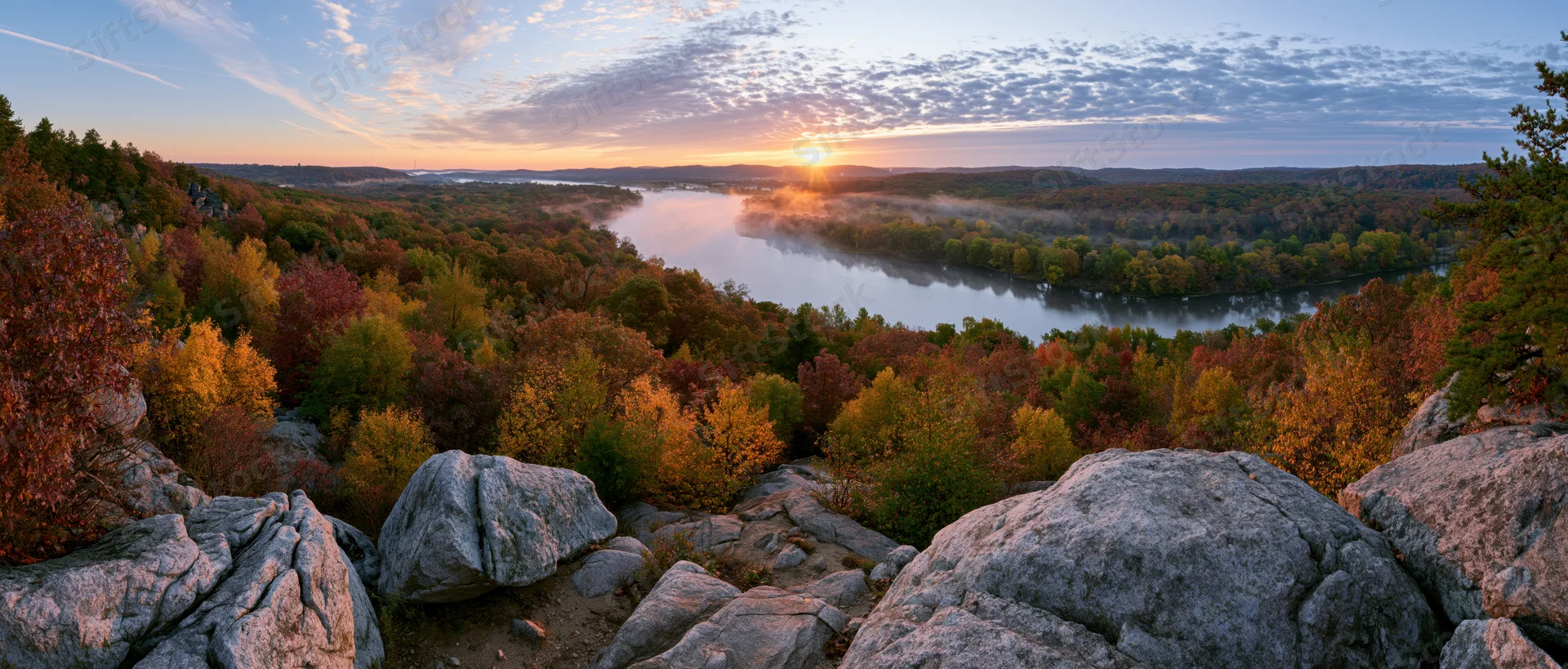 River winding through autumn forest at sunrise viewed from rocky overlook