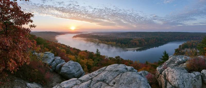 River winding through autumn forest at sunrise viewed from rocky overlook
