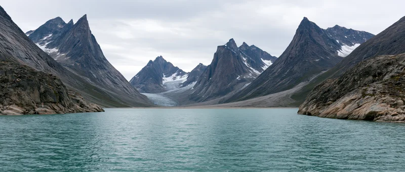 Alpine lake surrounded by snow-capped mountains and glaciers in a remote valley