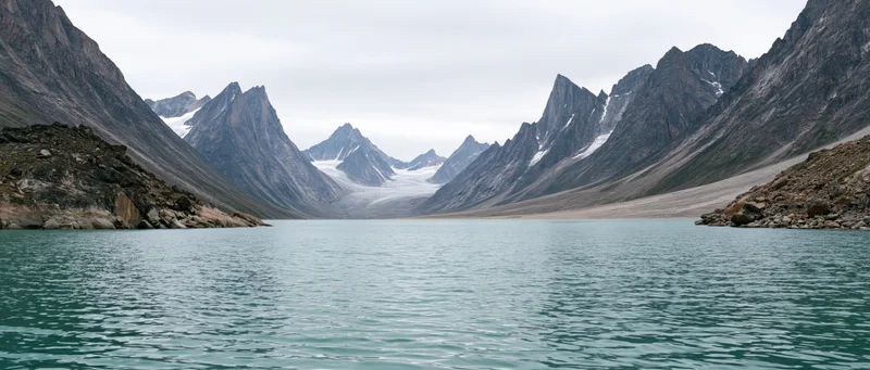 Turquoise lake nestled between jagged alpine peaks with a glacier in the valley beyond