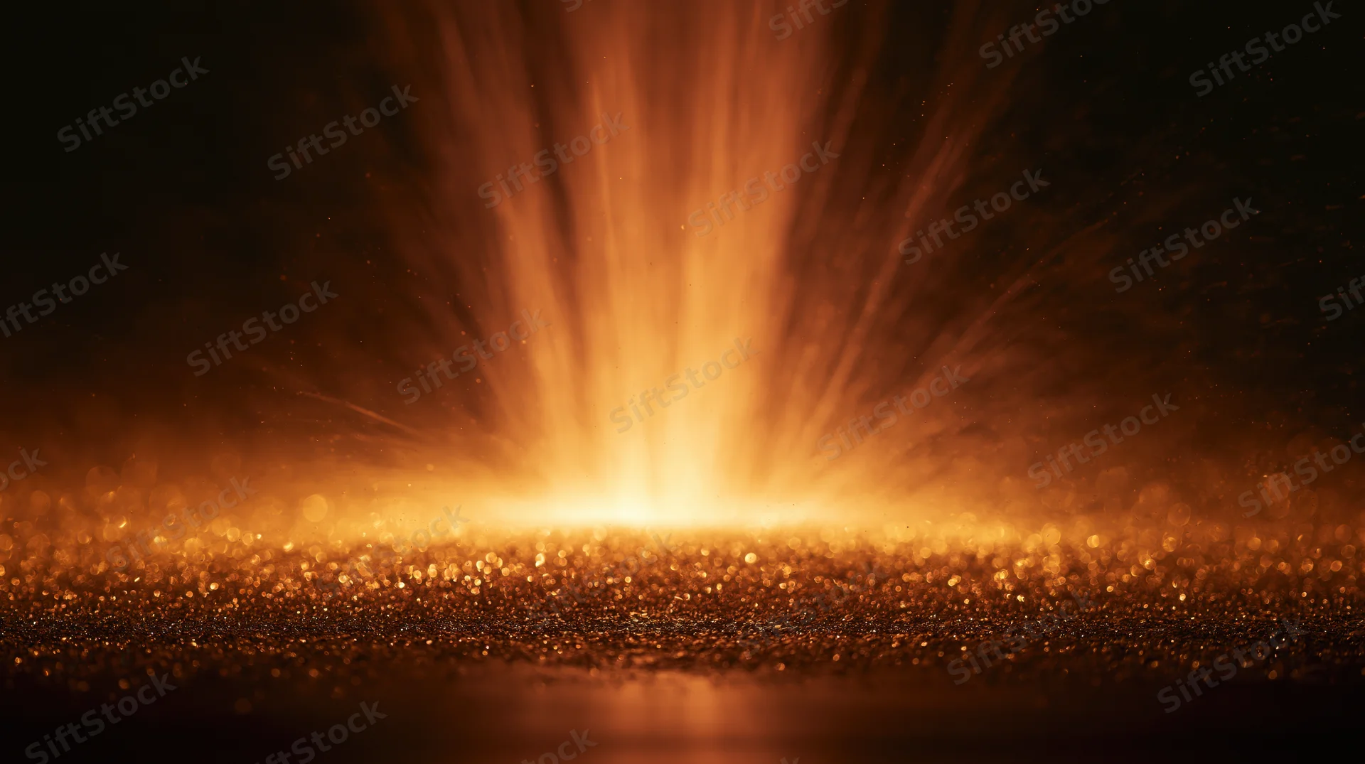 Radiant golden light bursting from a glittering surface against a dark background