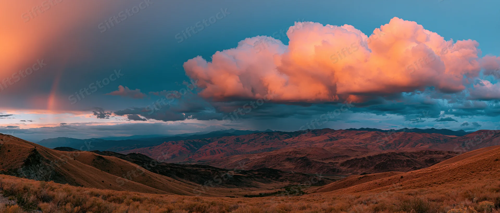 Desert mountains under pink and blue clouds at sunset