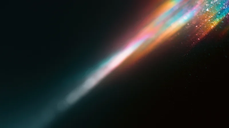 Diagonal rainbow light spectrum glowing across dark background with sparkling particles