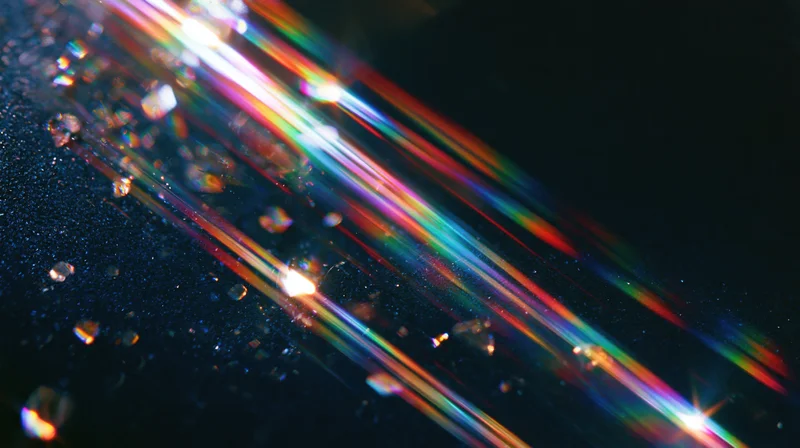 Colorful light beams refracting through water droplets on a dark surface