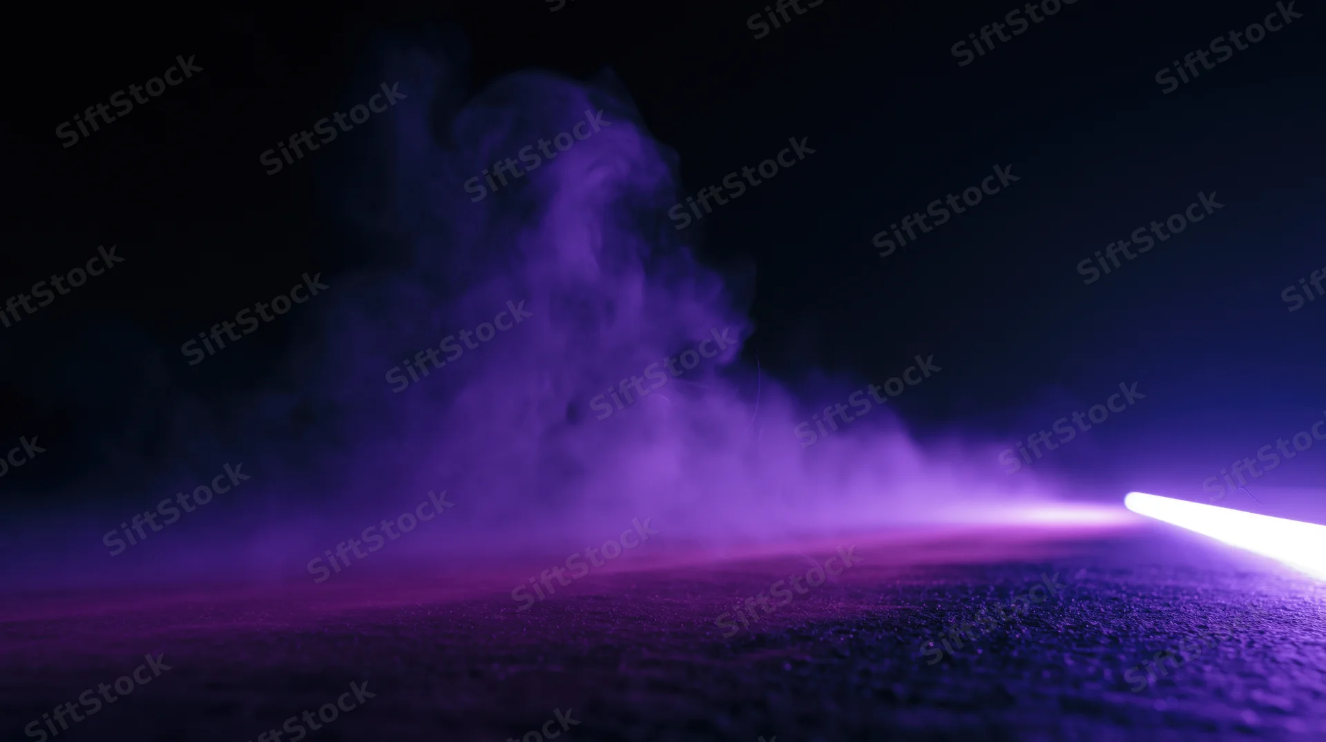 Purple smoke billowing across dark ground illuminated by a bright light beam