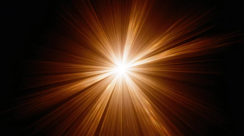 Radiant light burst with golden rays emanating from center against black background