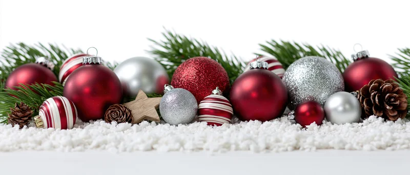 Christmas ornaments arranged with pine branches and pinecones on artificial snow