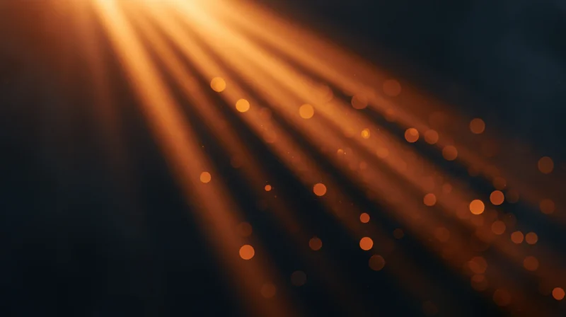 Golden light rays with bokeh particles in dark background