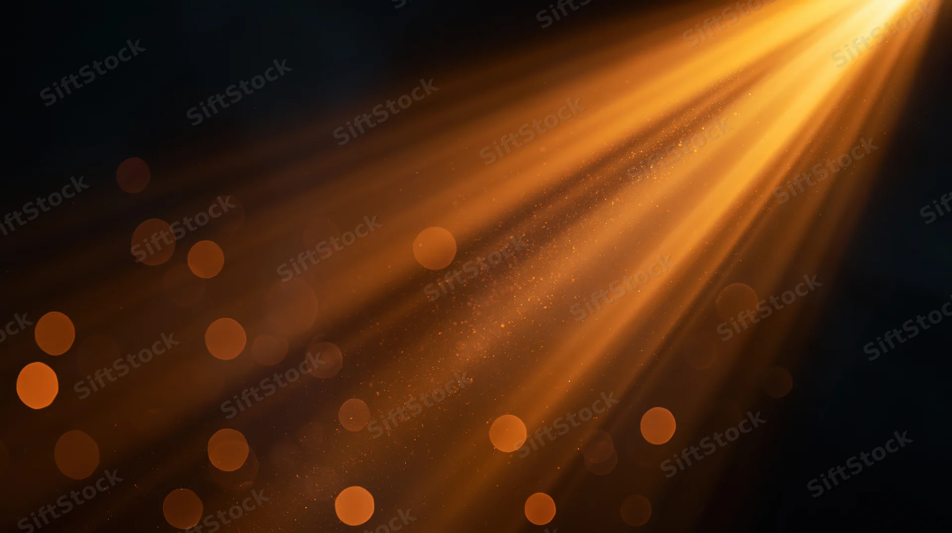 Golden light rays shining through dust particles in dark space with bokeh highlights