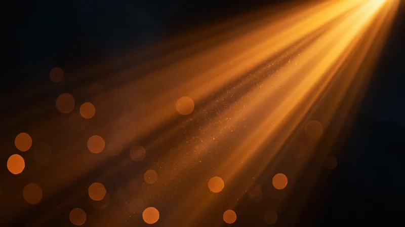 Golden light rays shining through dust particles in dark space with bokeh highlights