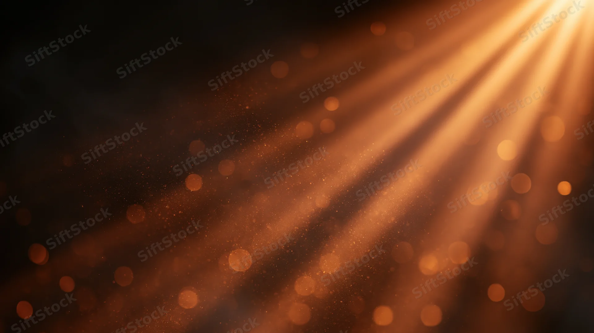 Golden light rays shining through dust particles in a dark space with bokeh highlights