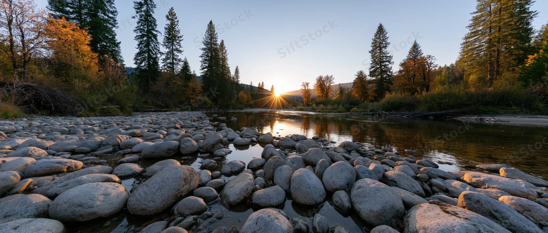 River flowing over smooth rocks at sunset in a forested valley