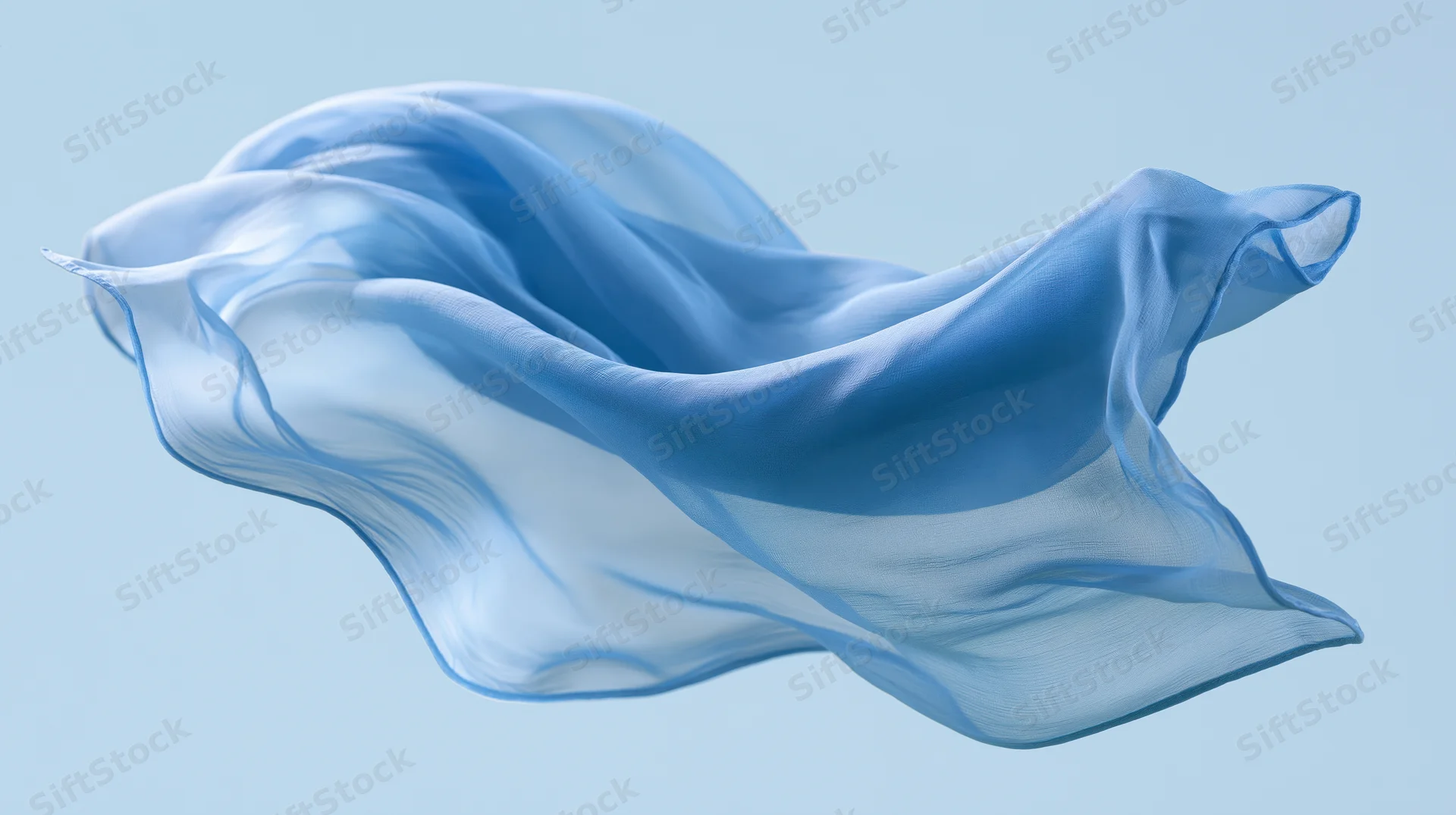 Flowing blue silk fabric drifting in mid-air against a light blue background