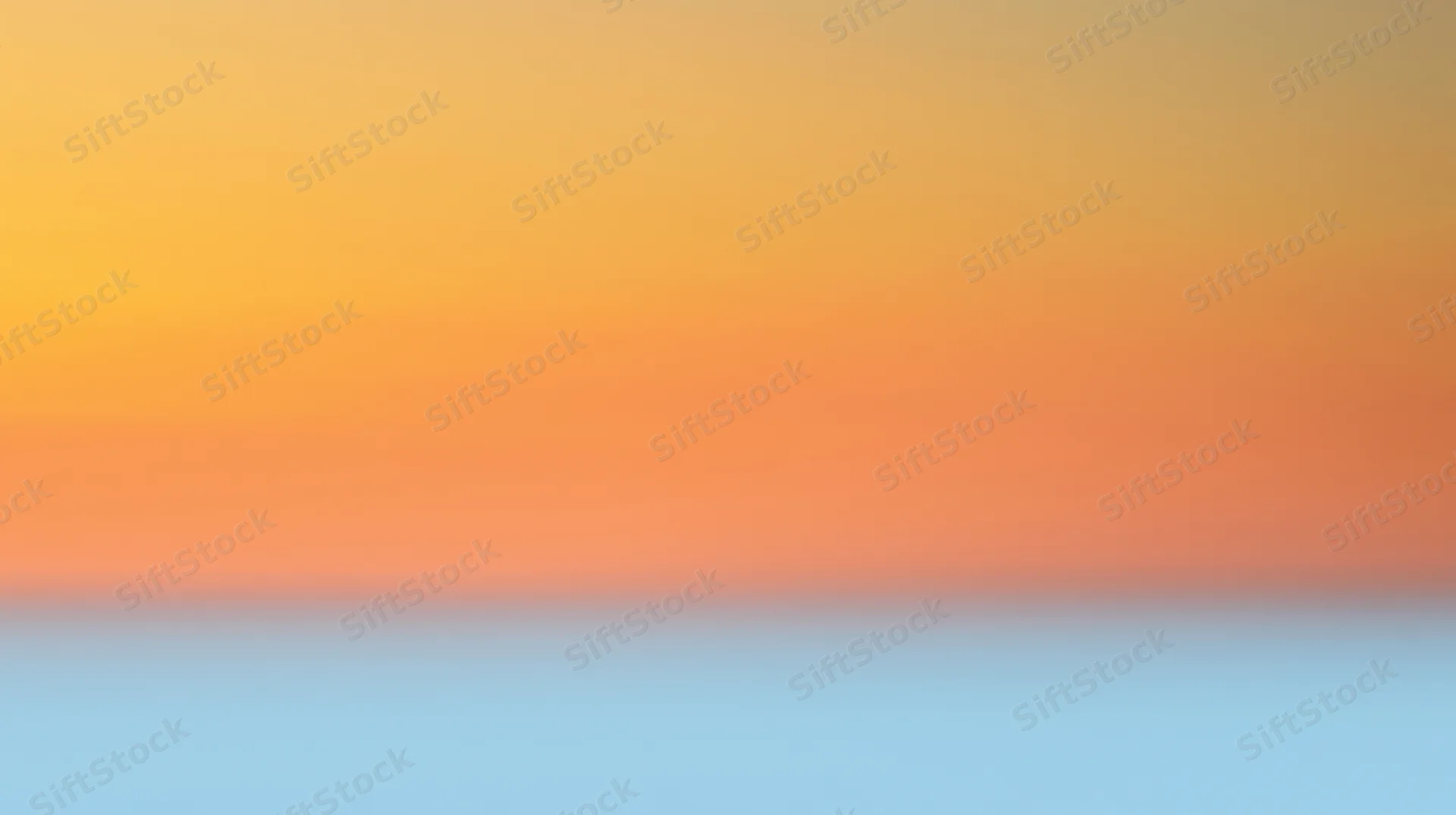 Gradient sky transitioning from orange to blue at sunset horizon