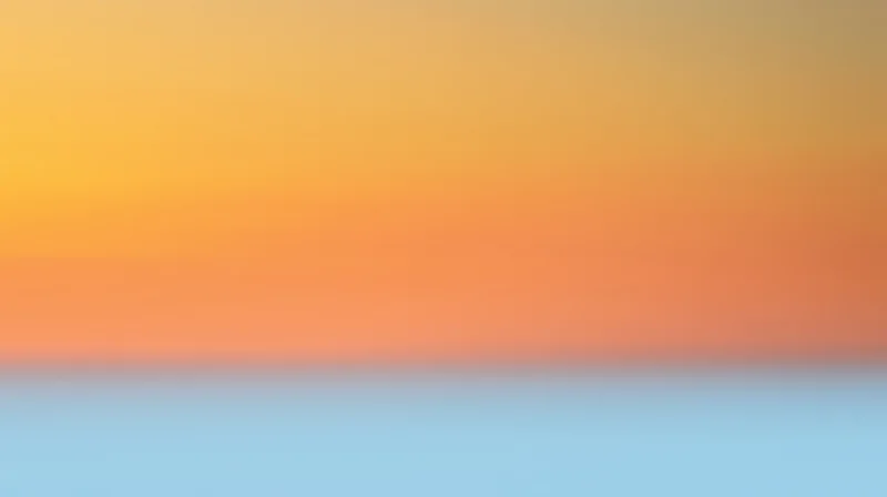 Gradient sky transitioning from orange to blue at sunset horizon
