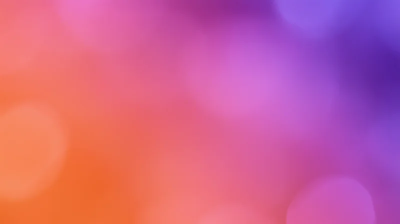Blurred bokeh lights in a gradient of pink, purple, and orange hues forming a soft abstract background