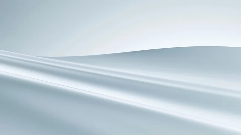 Smooth flowing white and silver gradient surface with soft light waves
