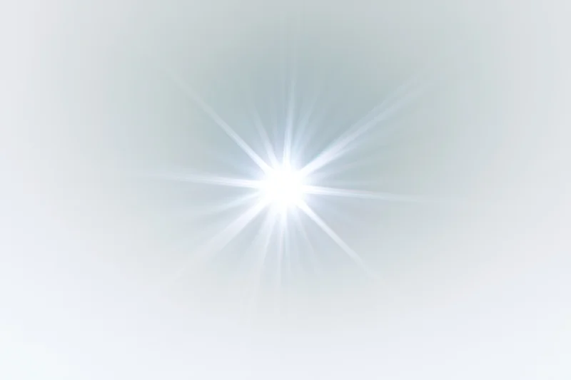 Bright lens flare starburst radiating from center against soft white gradient background