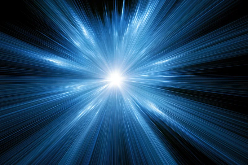 Glowing blue light burst radiating outward from center in dark space