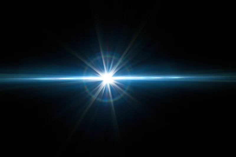 Bright blue-white lens flare centered on dark background with horizontal light beam and starburst rays