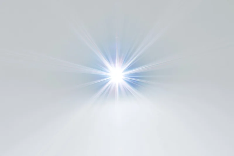 Bright lens flare starburst centered on white background