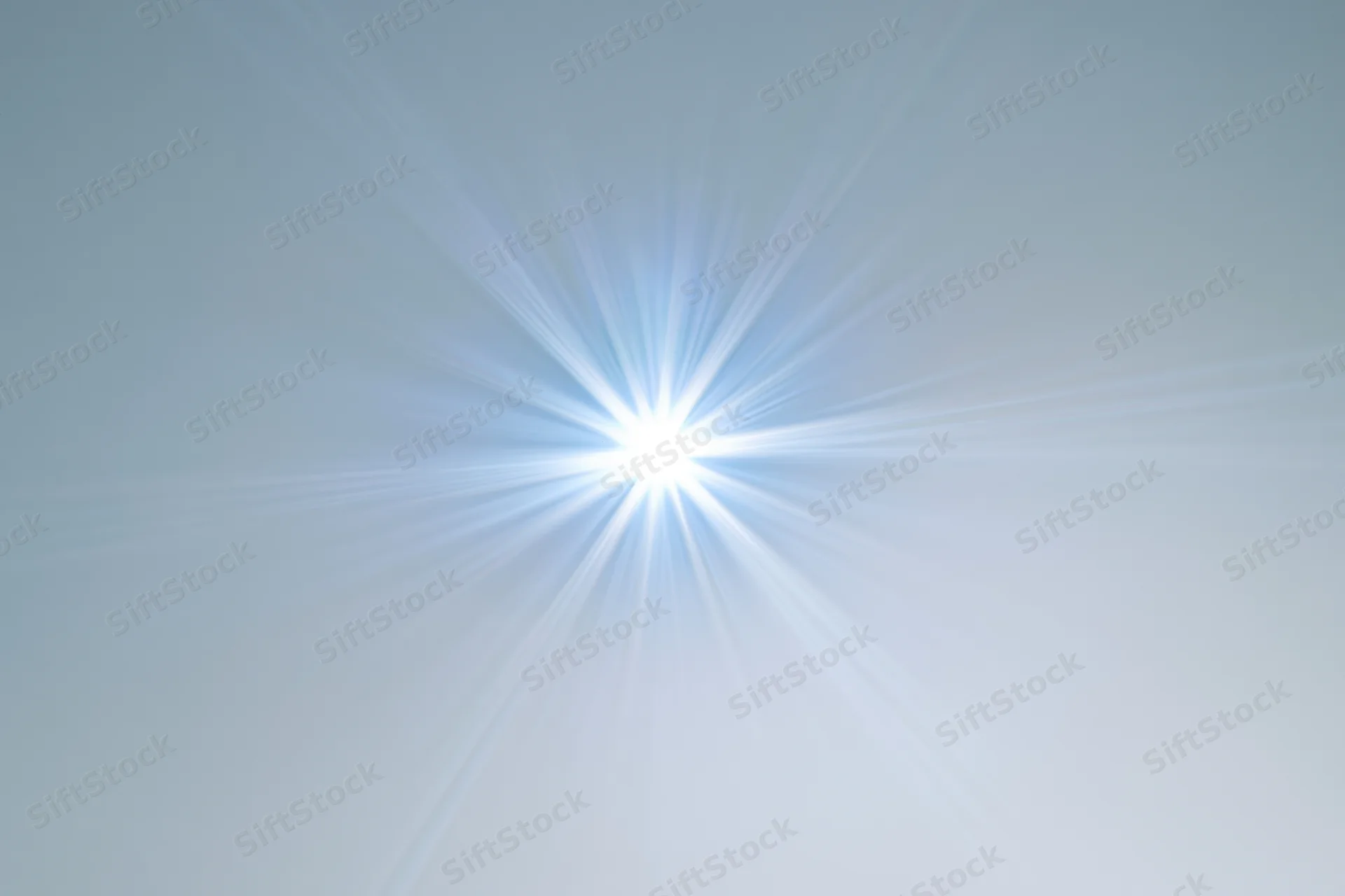 Bright lens flare starburst radiating from center on white background