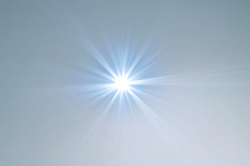 Bright lens flare starburst radiating from center on white background