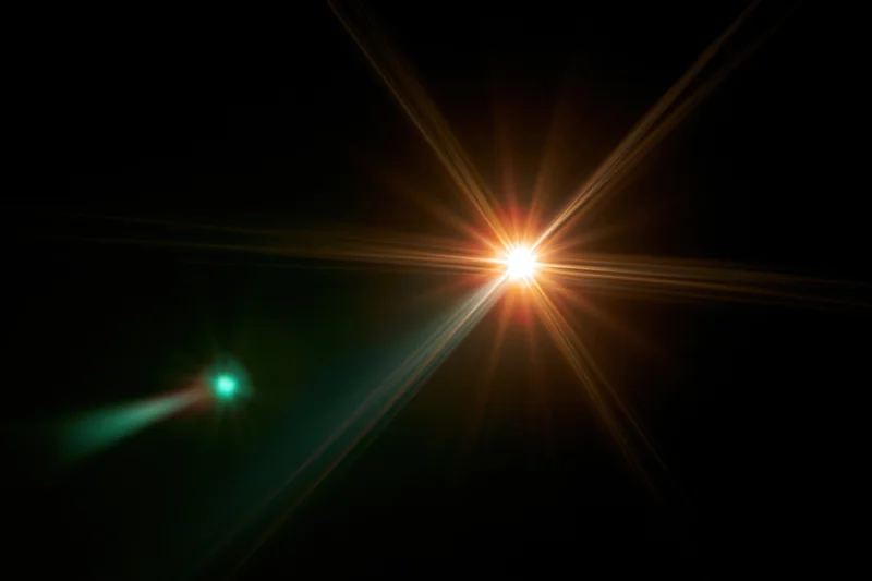 Bright point light source glowing with starburst flare against dark background