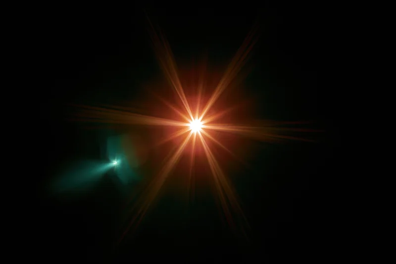 Bright point light source glowing with starburst flare against black background