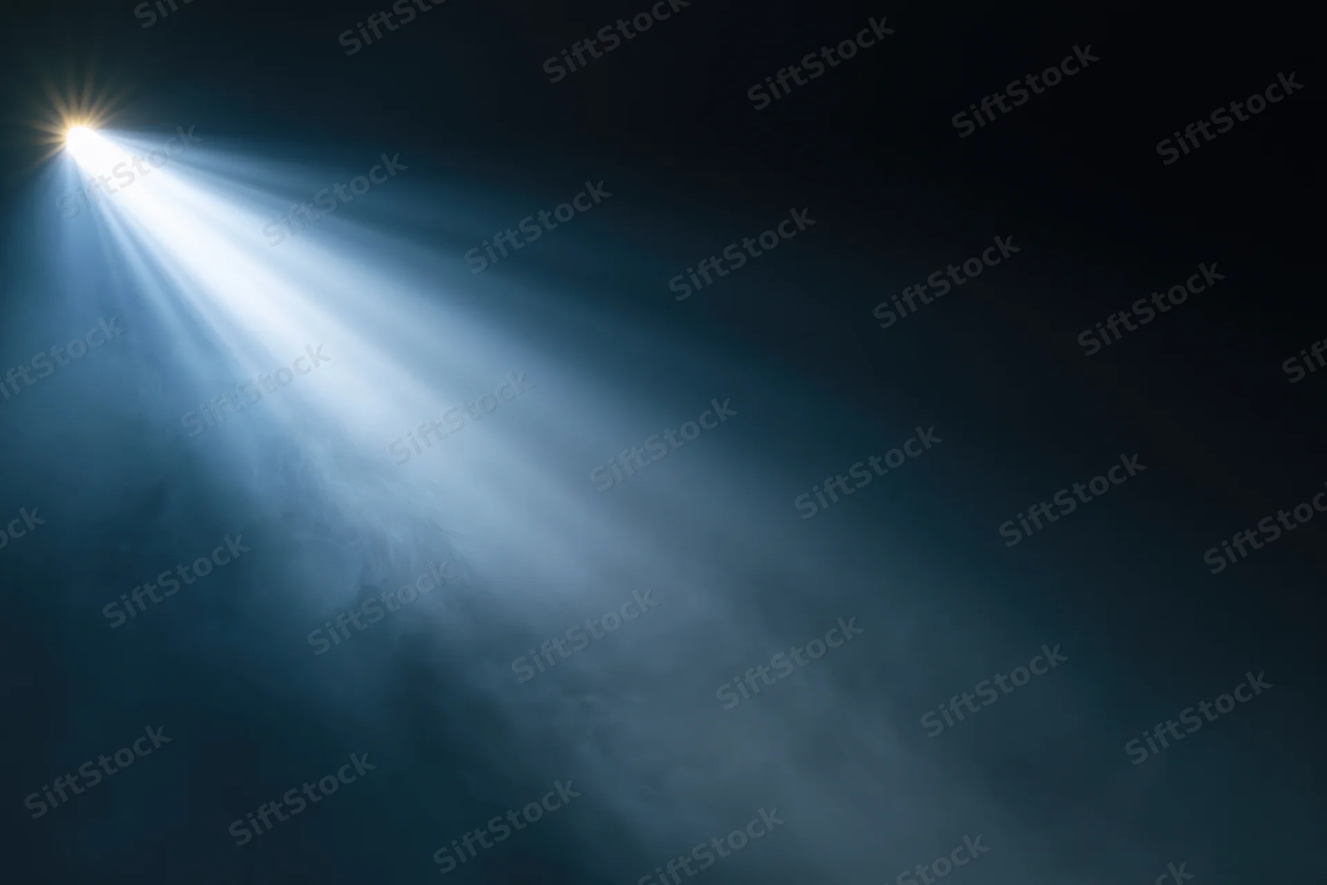Bright spotlight beam cutting through haze and smoke in a dark space