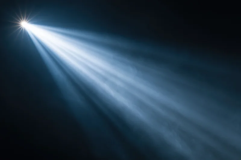 Bright spotlight beam cutting through haze and smoke in dark space
