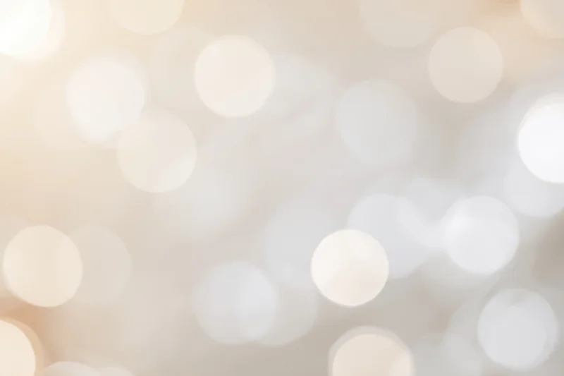 Soft out-of-focus light orbs in warm neutral tones forming an abstract bokeh background