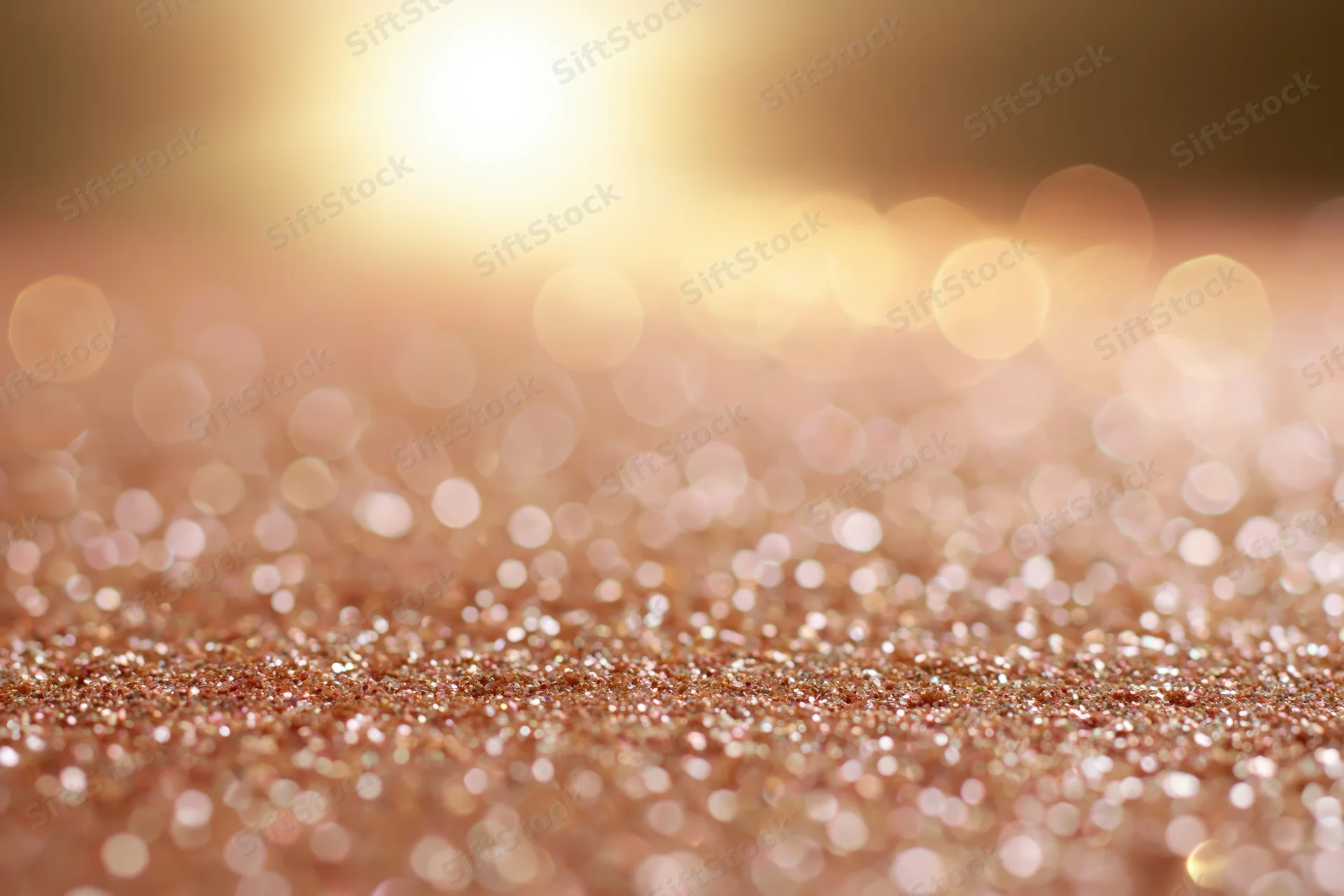 Abstract glitter surface with warm bokeh lights scattered across the frame