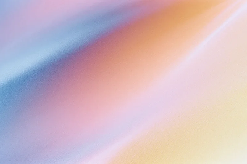 Smooth diagonal gradient of pastel colors blending across the frame as a textured background