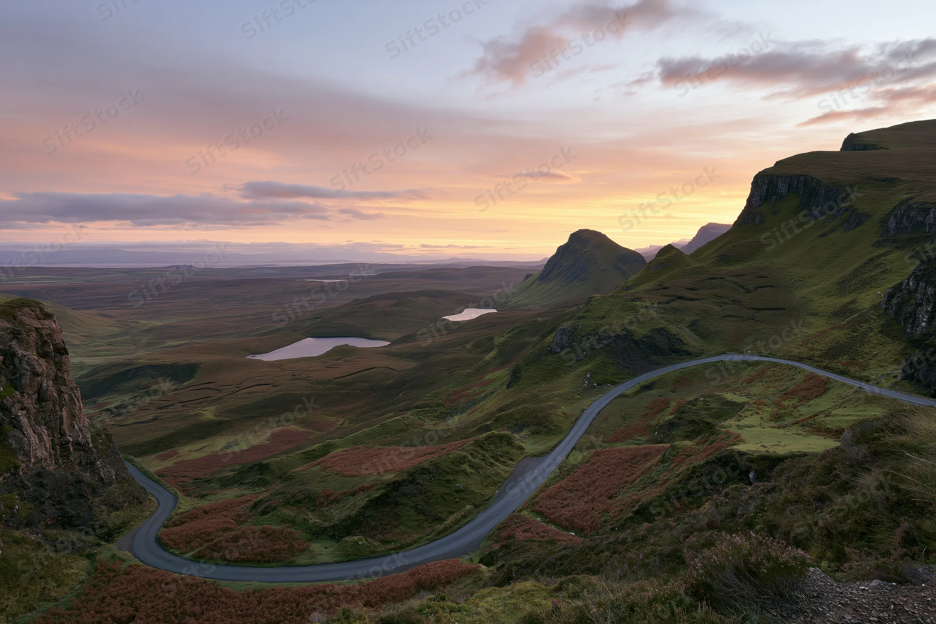 Winding single-track road through mountainous valley at sunset