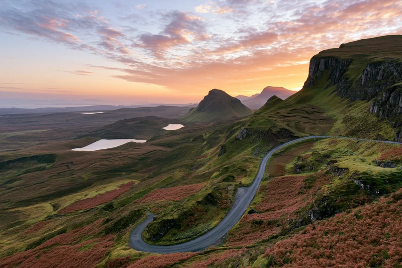 Winding single-track road through mountainous highland landscape at sunset