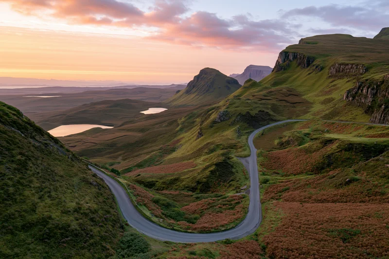 Winding single-track road through mountainous valley at sunset