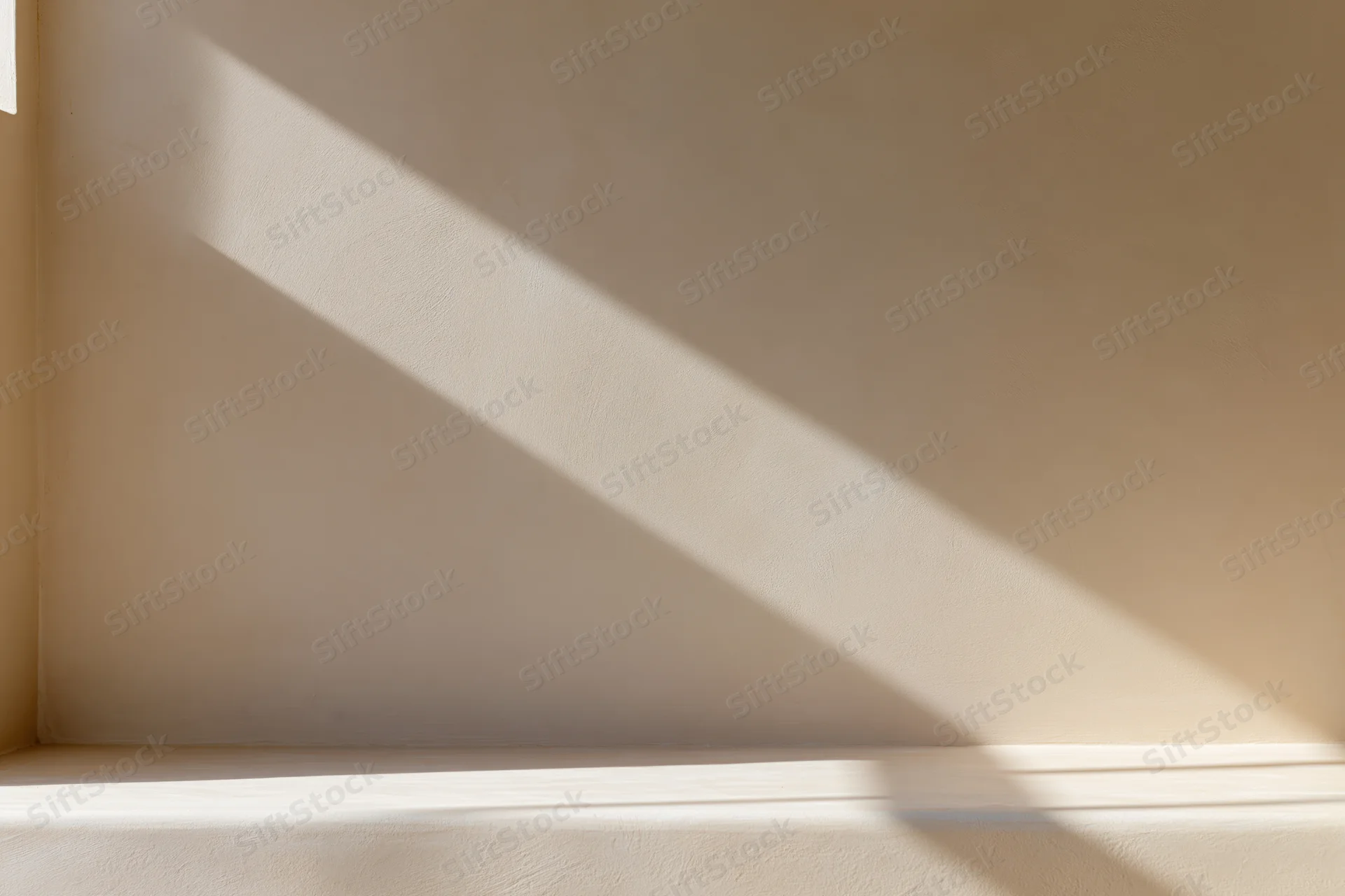 Diagonal sunlight shadow on beige plaster wall interior corner