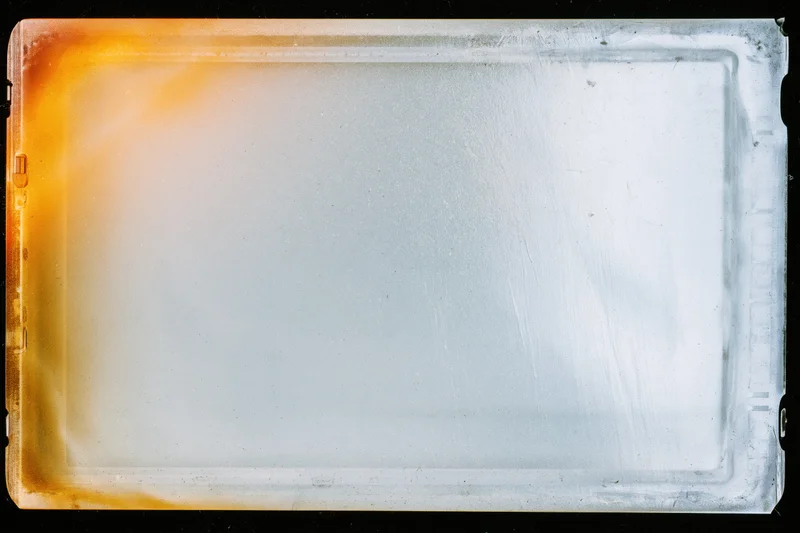Blank exposed film scan lying flat in extreme closeup filling frame with visible scratches and color gradient along edges