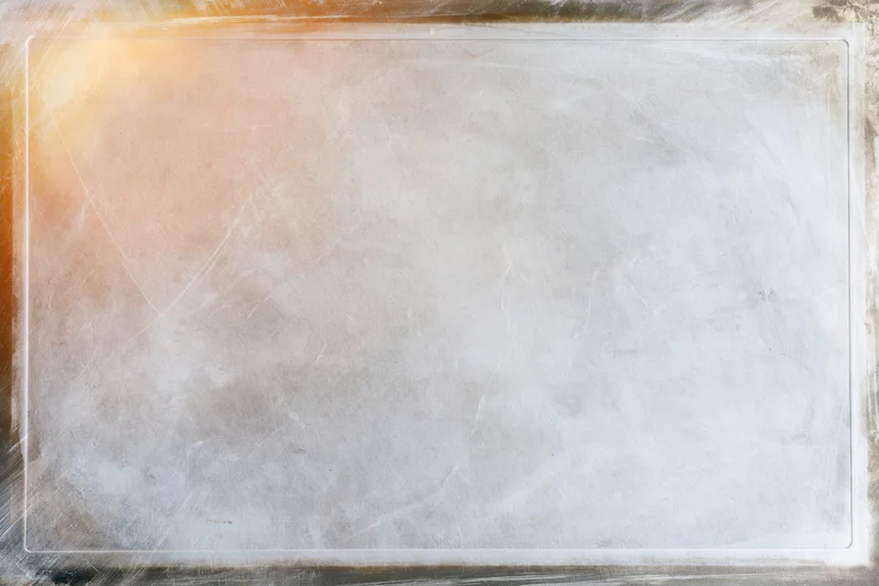 Textured vintage film slide surface with warm glow and border, showing aged paper-like material with scratches and copyspace