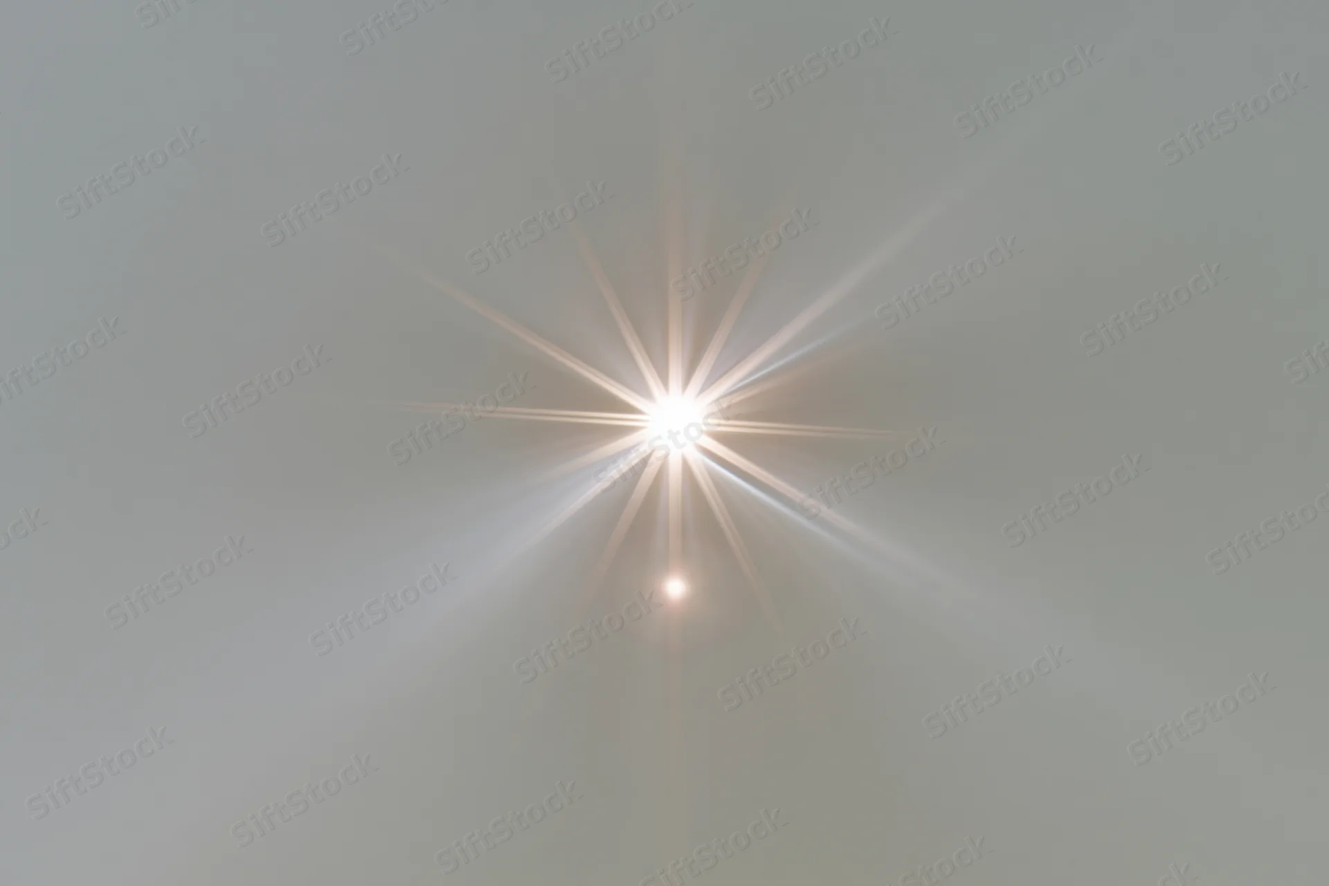 Bright lens flare burst centered on a plain light gray background