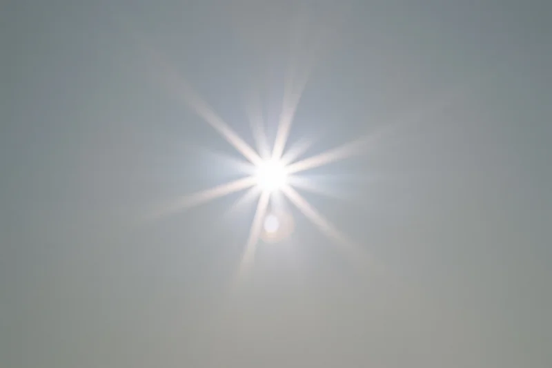 Bright lens flare burst centered on a plain light grey background