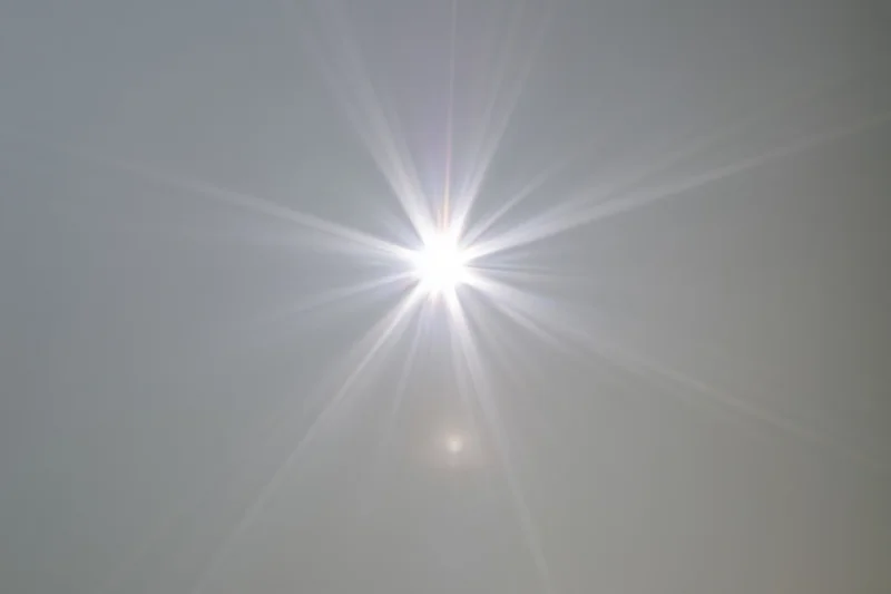Bright lens flare burst centered on a plain light grey background