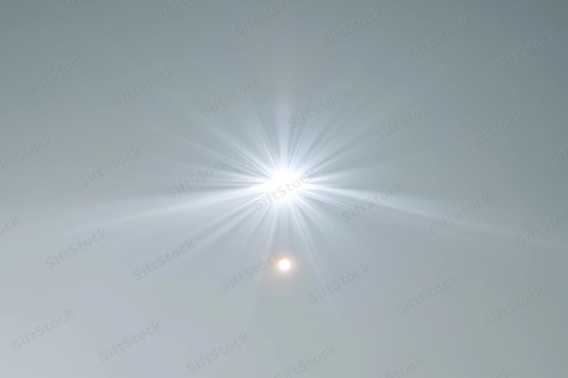 Bright lens flare burst centered on a plain light grey background