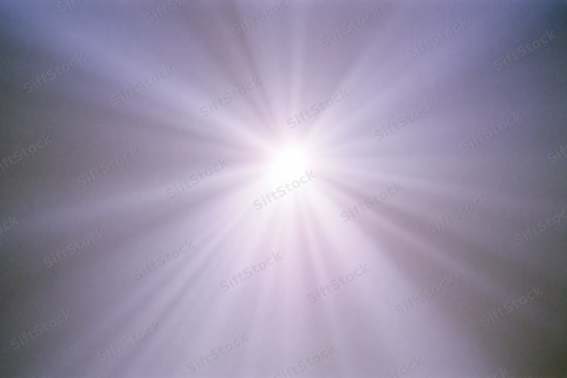 Bright lens flare burst radiating downward rays across a plain background