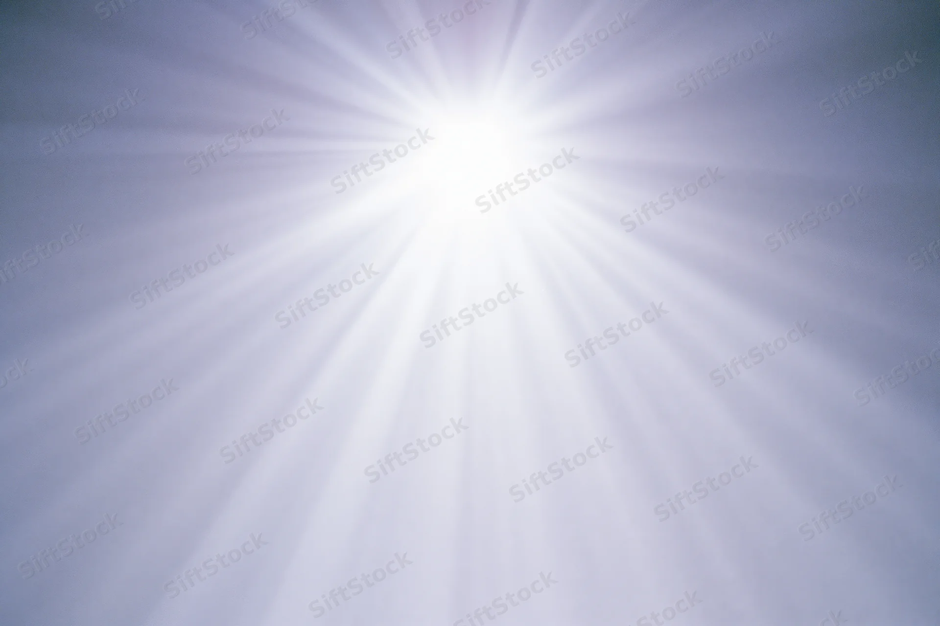 Bright lens flare burst radiating downward rays across a plain background