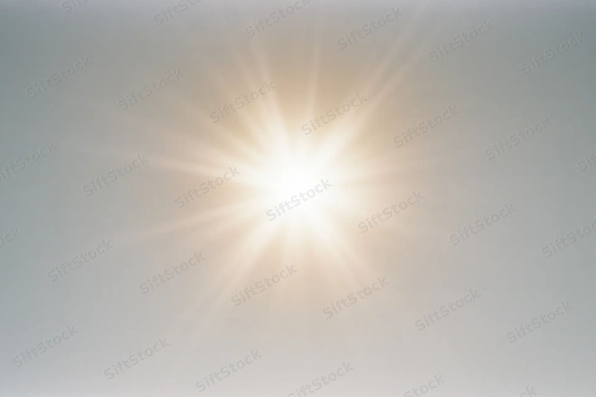 Bright midday sun glowing against a pale white sky