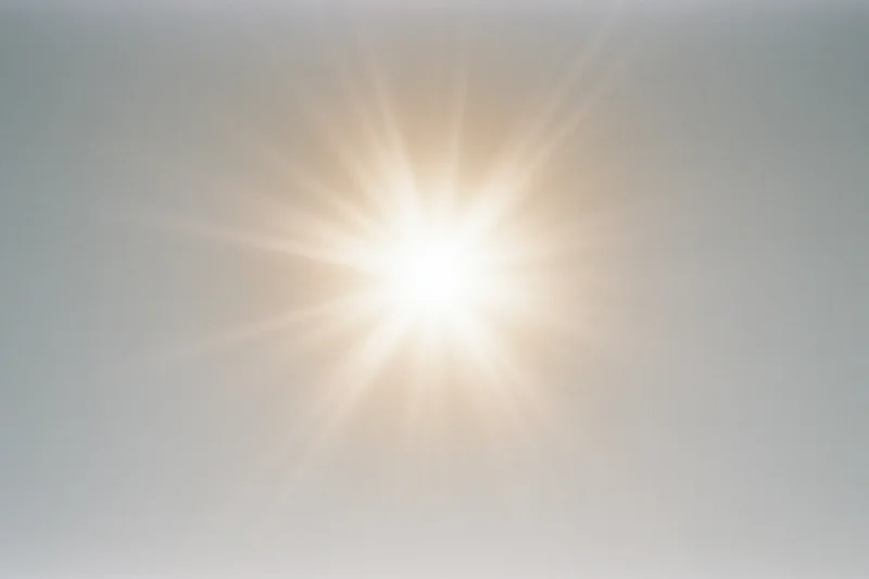 Bright midday sun glowing against a pale white sky