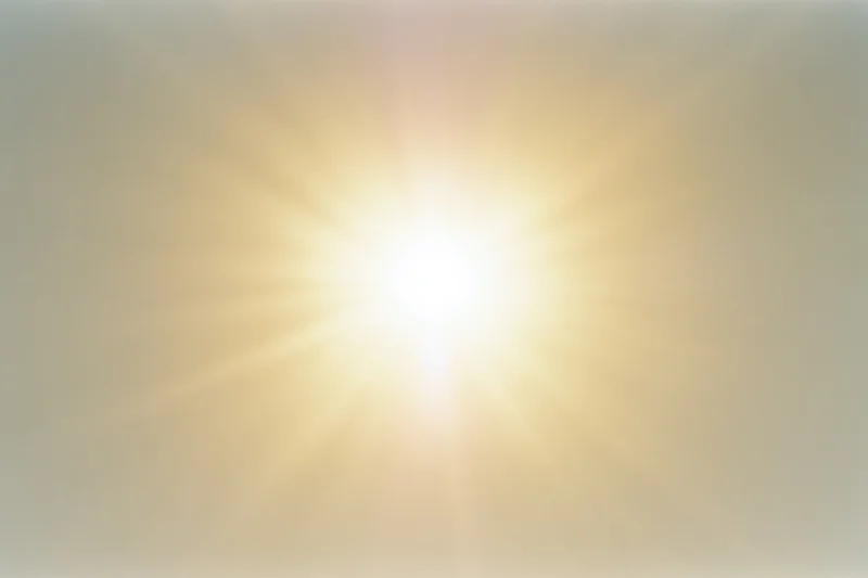 Bright midday sun glowing intensely against a pale white sky