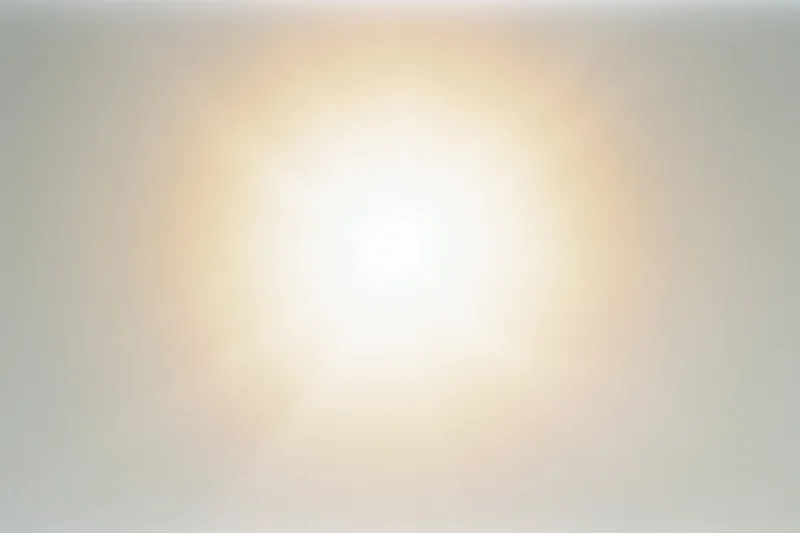 Bright midday sun glowing intensely against a pale white sky